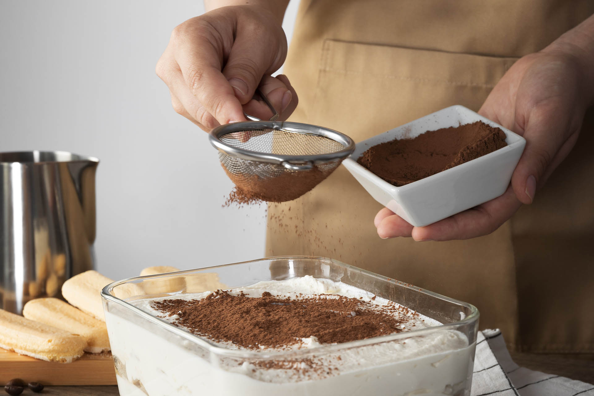 La spolverata di cacao amano con il setaccio, il tocco finale per un tiramisù buono e che si presenta bene